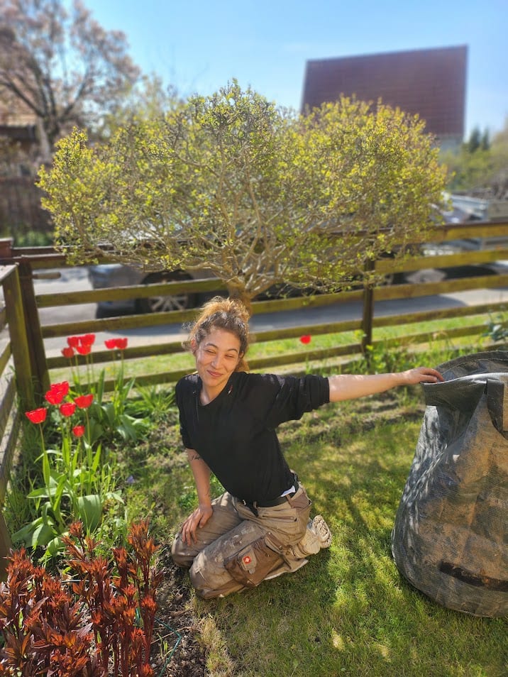 Jatoba anlægsgartner i gang med havearbejde mellem blomster
